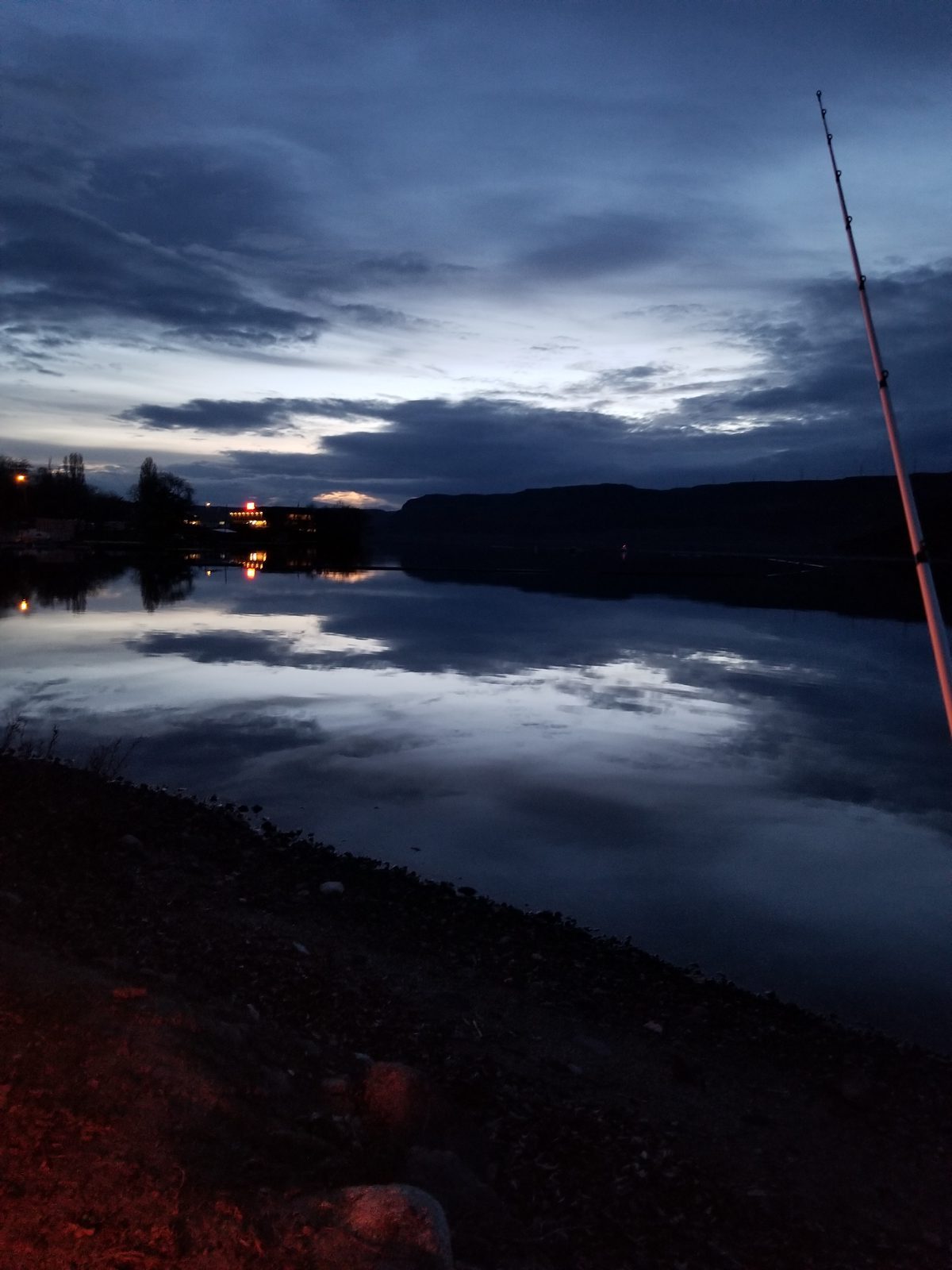 Fishing rod at dusk over calm water